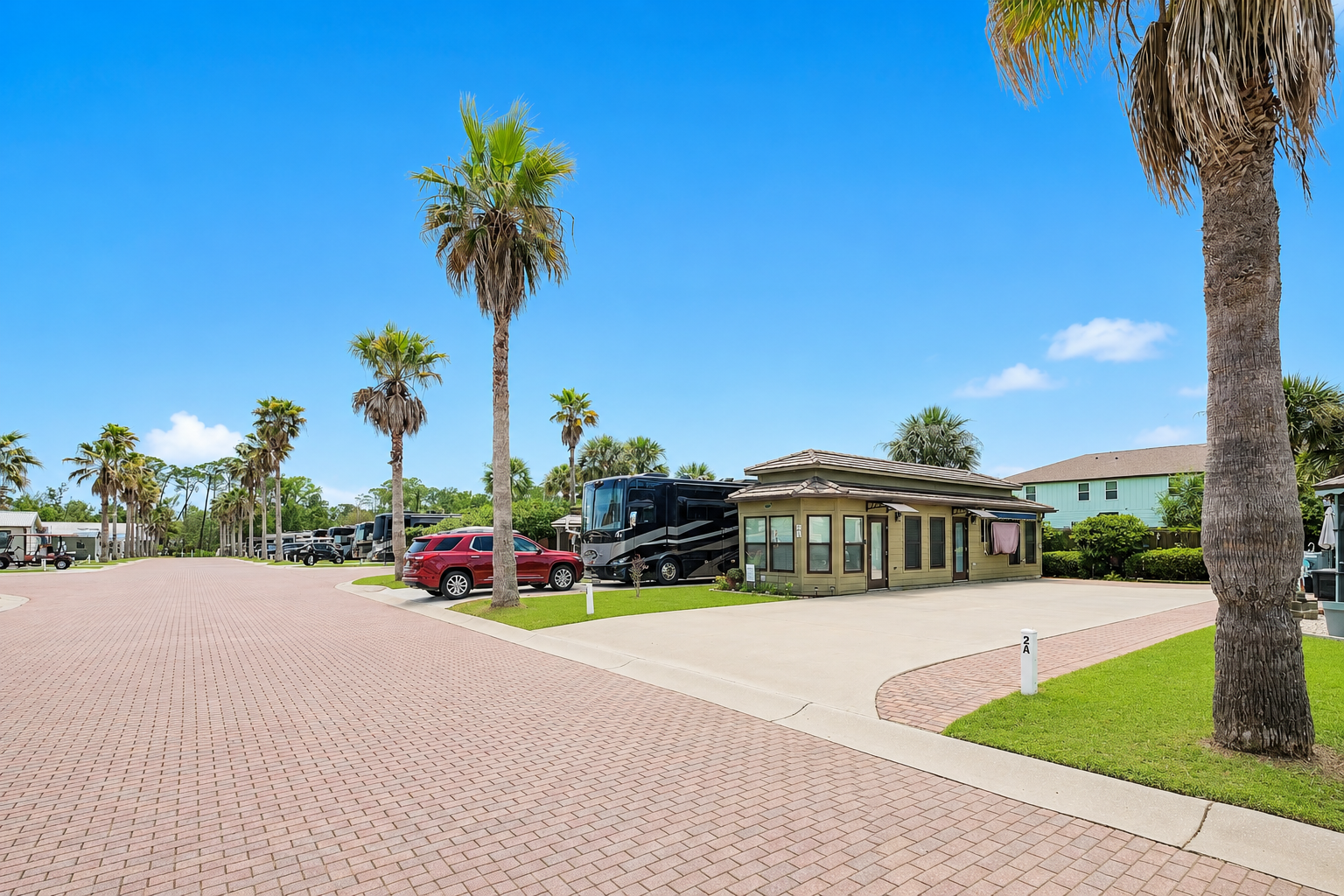 Lot 2A at Terry Cove Motor Coach Resort — palm-lined street with coach house