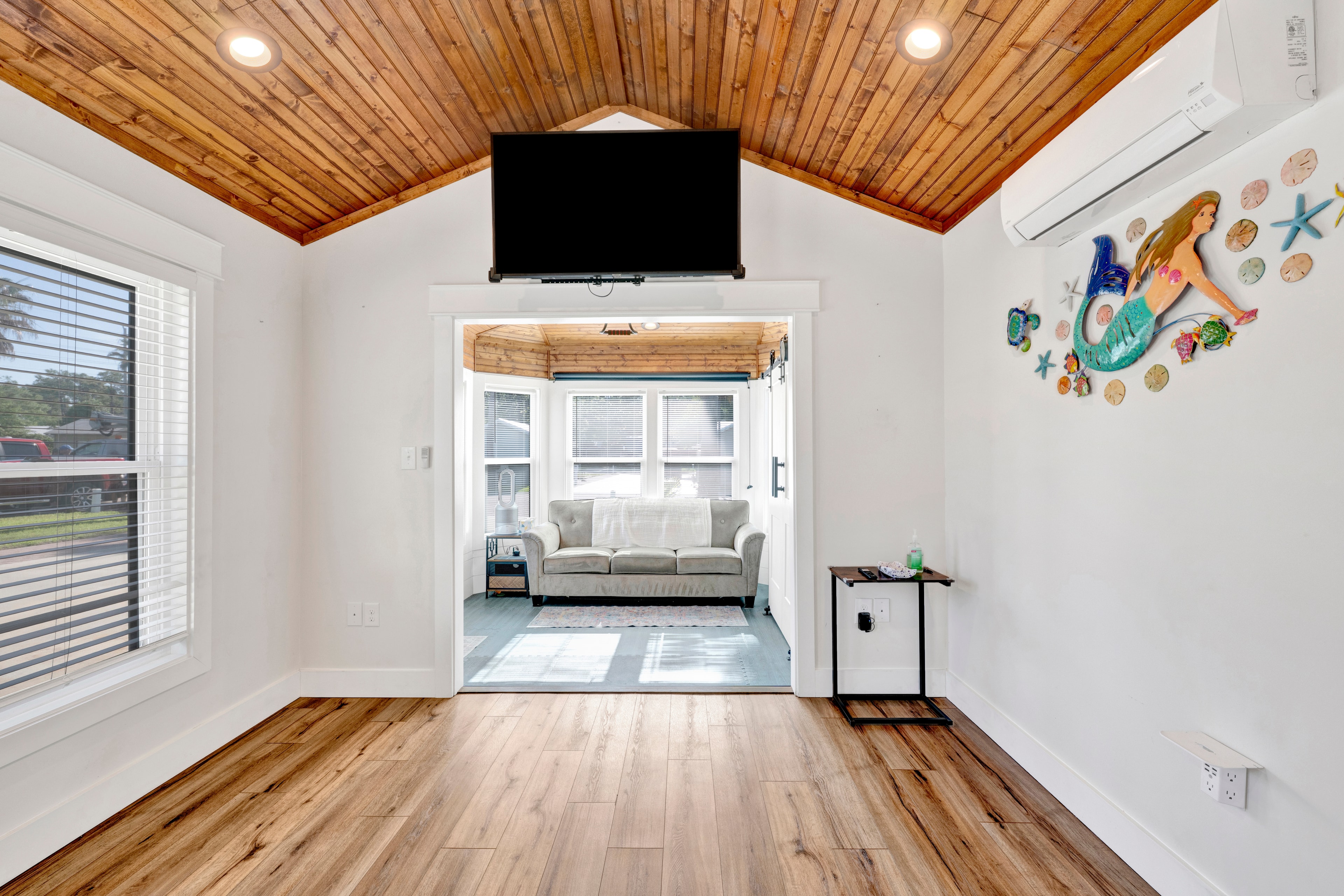 Coach house interior with wood ceiling, window and coastal decor at Terry Cove Lot 2A
