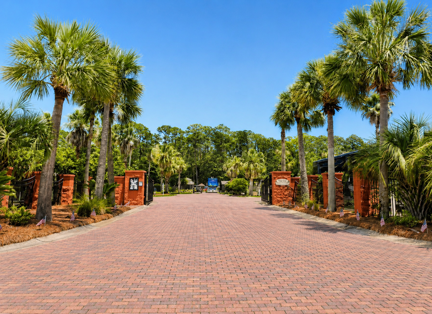 Palm-tree-lined brick entrance to Terry Cove Motor Coach Resort, Orange Beach Alabama
